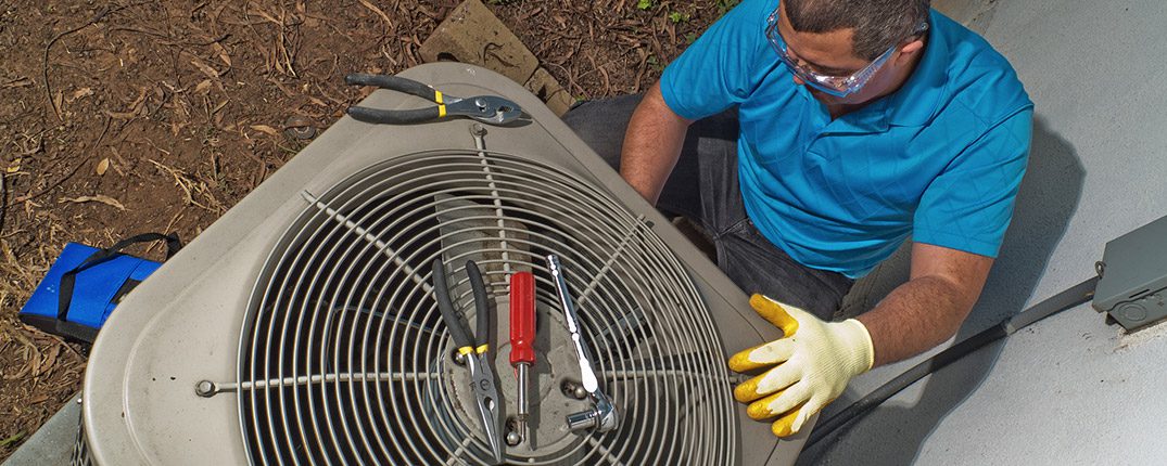 DunRite Heating & Air Inc. - Man fixing air conditioner