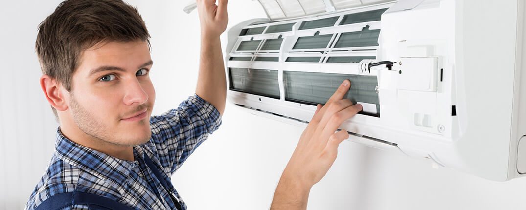 DunRite Heating & Air Inc. - Male Technician Repairing Air Conditioner